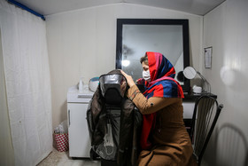 کتایون آقایی، ۲۴ ساله، دارای ۲فرزند است. قبل از زلزله در آرایشگاه بزرگی در مرکز شهر مشغول به کار بوده و اکنون آرایشگری را در داخل کانکس با خدمات نصف قیمت ارائه میدهد. همسر کتایون موبایل فروشی داشته و به دلیل تخریب مغازه تمام سرمایه آنها از دست رفته است.